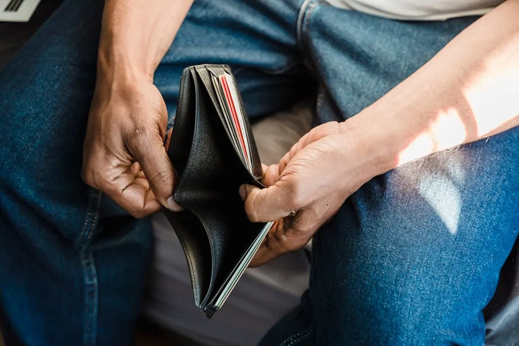 5 Things to Do If You’re Always Broke 1 Close-up of a man holding an empty wallet, symbolizing financial crisis and hardship.