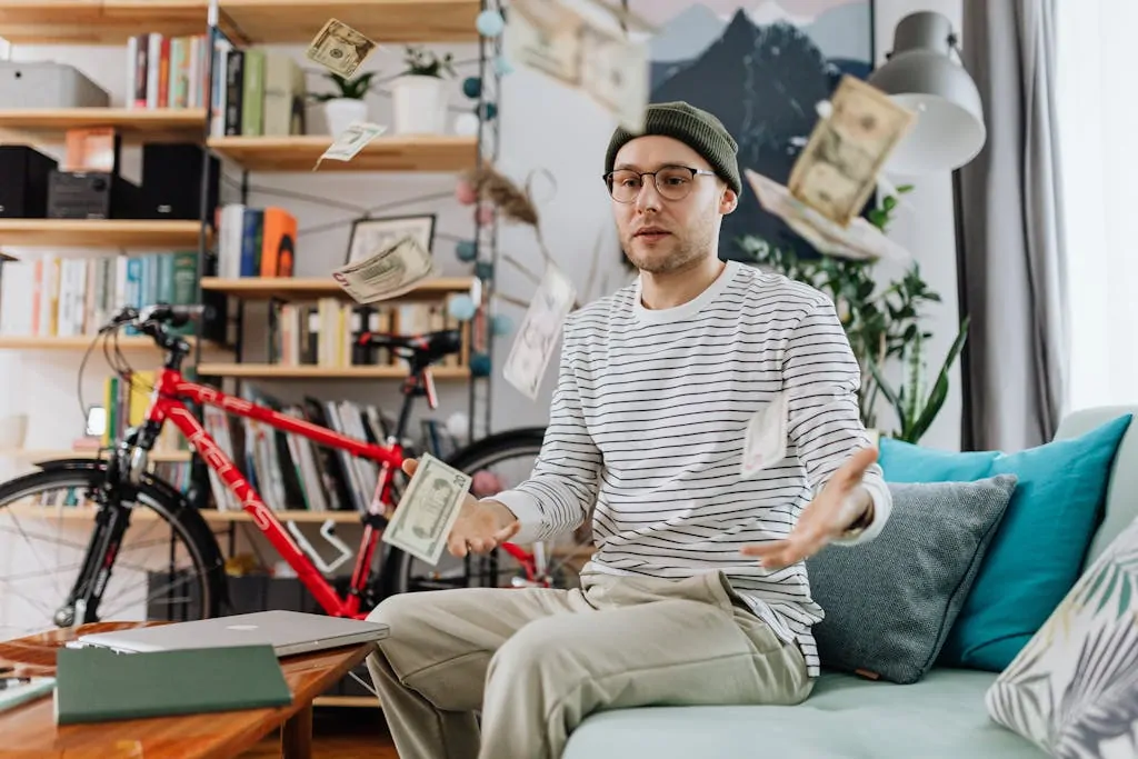 Young man tossing money in a cozy room, showcasing indoor leisure and wealth.