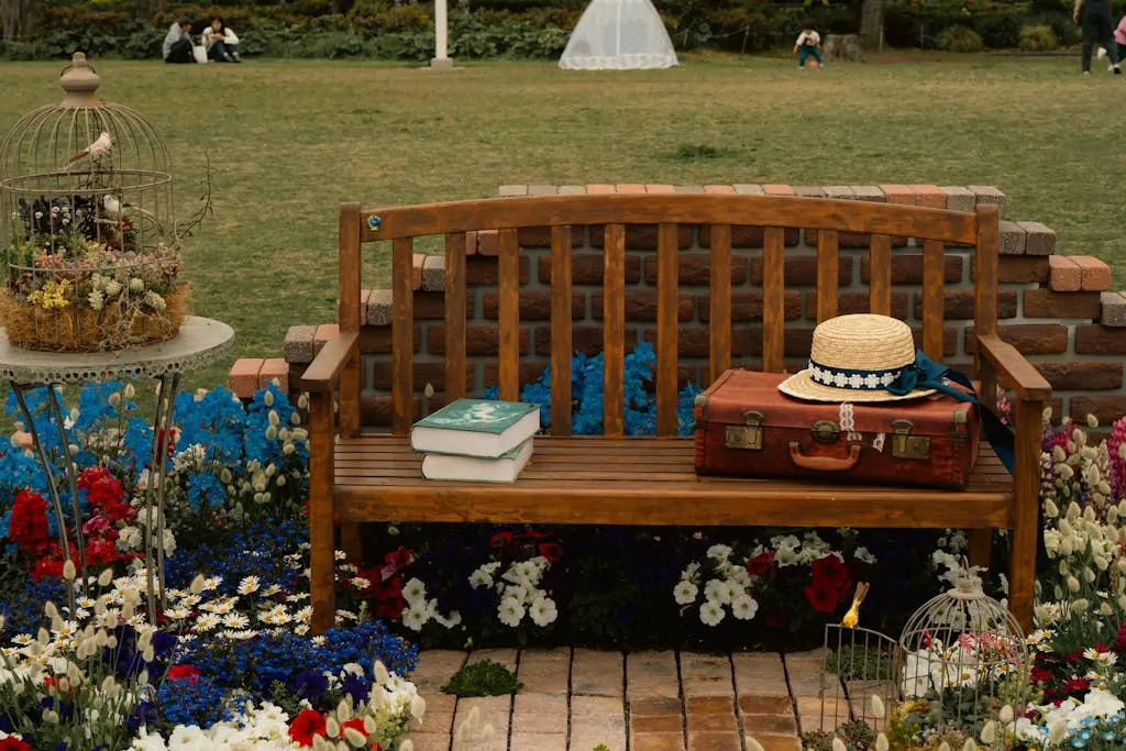 A vintage bench in a Yokohama garden surrounded by flowers, books, and a birdcage.