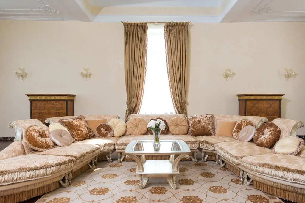 13 Cheap Living Tips That Still Feel Luxurious 1 Interior of comfortable spacious living room with soft pillows on long couch and glass table with vase filled with flowers