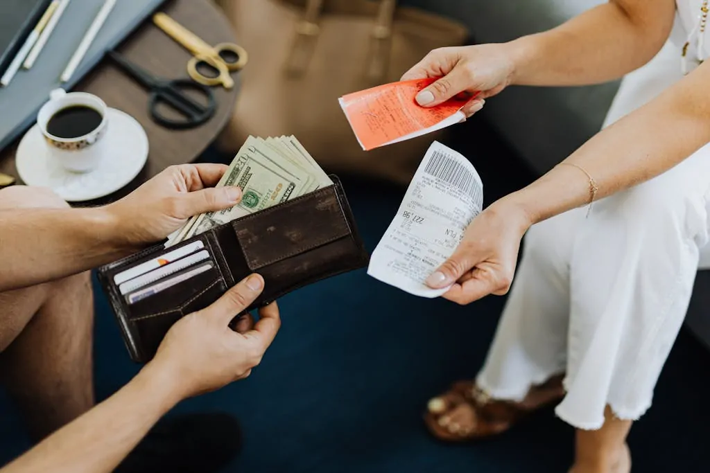 15 Smart Ways to Spend Money Without Regret 1 Close-up of a financial transaction involving cash and receipts over a coffee table.